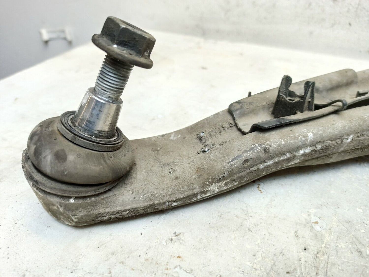 Close-up of a worn front lower wishbone control arm for a Mercedes-Benz, highlighting potential suspension issues.